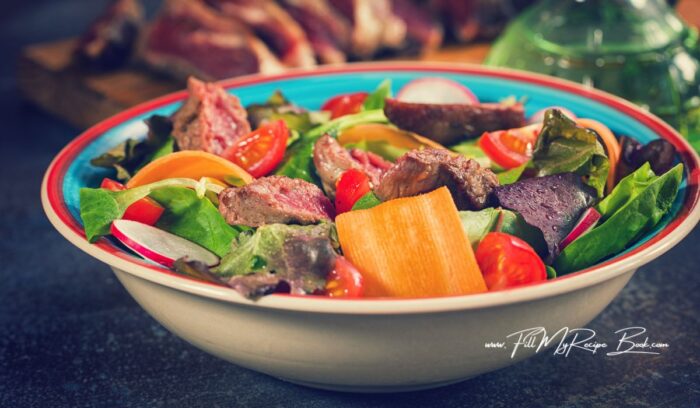 Clean and slice your radish and your tomatoes. Make your sweet carrots into ribbons.
Break apart the lettuce and baby spinach. Add into a bowl. Then add in the tomato and the radish and carrot ribbons.
Slice the steak into strips and place on top of the salad bowl of veggie and salads.