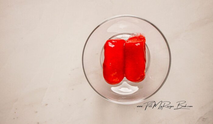 To assemble, cut the ladyfingers in half and start by lightly dipping the ladyfingers into the raspberry coulis, just a quick dunk. Lay them in the bottom of shallow dessert glasses, about 2 halves will fit (sizes will vary).