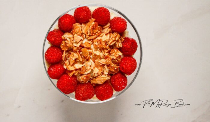 Optional, but ring the glass with fresh raspberries and scatter the almond crunch over the top of the mascarpone layer.