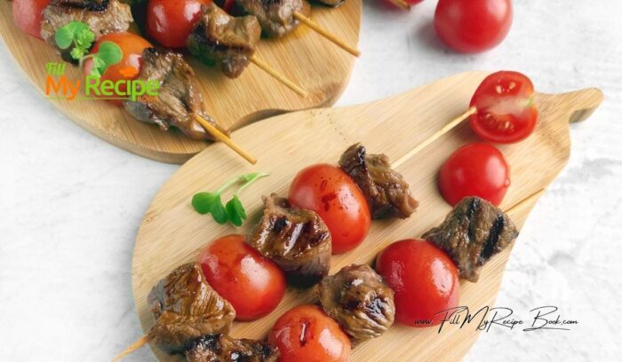 Moisten the wooden skewers with water. Alternately thread the steak and tomato halves onto the skewers. If you have small cherry or cocktail tomatoes, thread them whole.