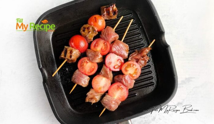 Place the skewers at a distance from each other and cook for three minutes until appetizing stripes appear on the meat. Turn the kebabs over and brush them with the reserved marinade. Cook for another 3 minutes. During this time, the tomato skin will char and the vegetables will become soft and juicy.