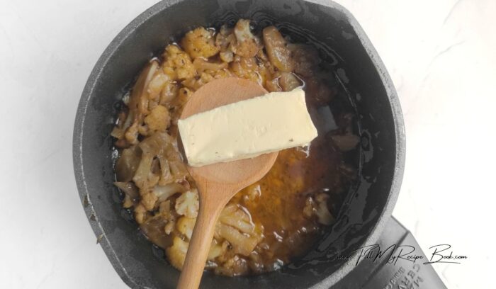 Set aside a few nice-looking florets for garnish. Add the roasted cauliflower to the pot with the onions. Pour in hot water to cover the vegetables. Bring the soup to a boil and simmer for 10 minutes. Add the bay leaf and simmer for 5 minutes. Remove the bay leaf. Add butter at the end of cooking.