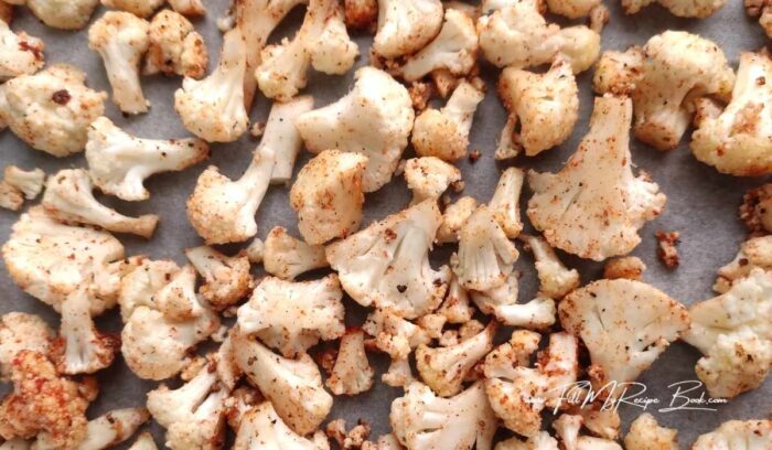 Cut the cauliflower into small florets and place in a bowl. Add salt, pepper, spices, olive oil, and leave to marinate for 20 minutes. Preheat the oven to 180 deg. C (356 deg F). Place the cauliflower florets on a baking sheet lined with parchment paper and bake for 20-25 minutes.