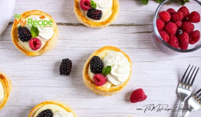 Spoon or pipe vanilla cream into each cooled pastry cup. Top with piped whipped cream, fresh berries, and mint sprigs.