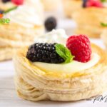 An easy Vanilla Cream Puff Pastry recipe idea for a dessert. Oven baked, topped with whipped cream and garnished with raspberries, mint.