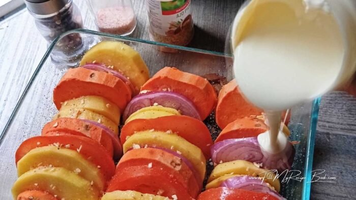 Start to arrange your different ingredients, standing up the slices, in a row. One regular potato  or two, then a slice of onion, then two slices of sweet potato, then a slice of tomato.
Continue in this way as you would like to arrange them. Until the dish is filled up.
Pour in your full cream. Brush the top of the potatoes with some olive oil, and sprinkle the Italian seasoning over them. (use small to medium potatoes, so the cream can cover most of the potatoes) or if a little larger halfway turn them around to absorbed the cream and give them flavor. This is why we also brushed the tops of the potato slices with olive oil. So they do not dry out and became a little crispy.