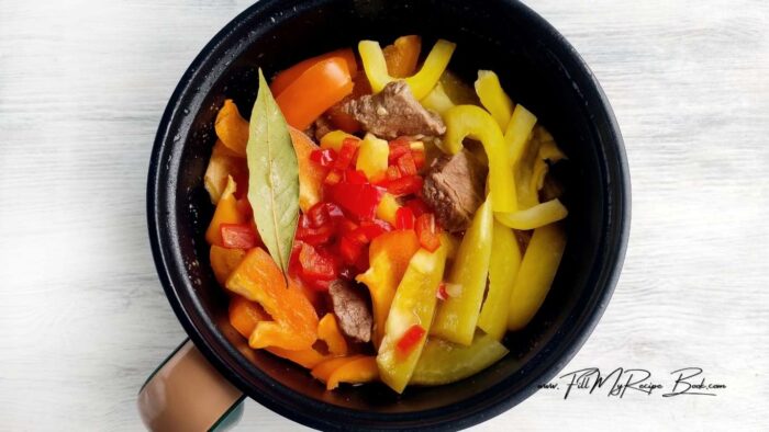 Peel and finely chop the onion. Fry it in a slow cooker on HIGH without a lid 
Peel the peppers, cut into strips and put in a slow cooker. Add bay leaf and allspice and cook for 40 minutes.