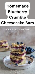 Baked Homemade Blueberry Crumble Cheesecake Bars, buttery shortbread base, cheesecake, juicy blueberry layers, with crumbed almond topping.