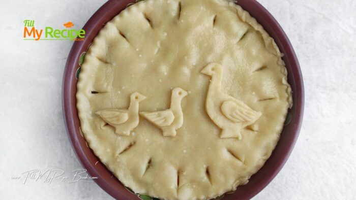 Sprinkle the mold with oil. Put 1 circle of dough, prick with a fork. Put the filling.
Place the 2nd circle of dough on top, cut off the excess. Roll out the excess into a layer. Print out the goose and gosling templates and form figures.