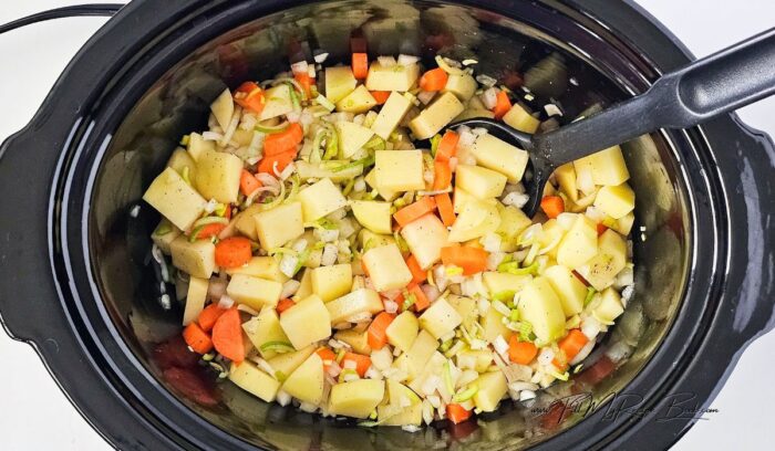 Homemade easy corned beef hash recipe with vegetables cooked in a slow cooker, then fry the corned beef and add it to the dish for for a meal.