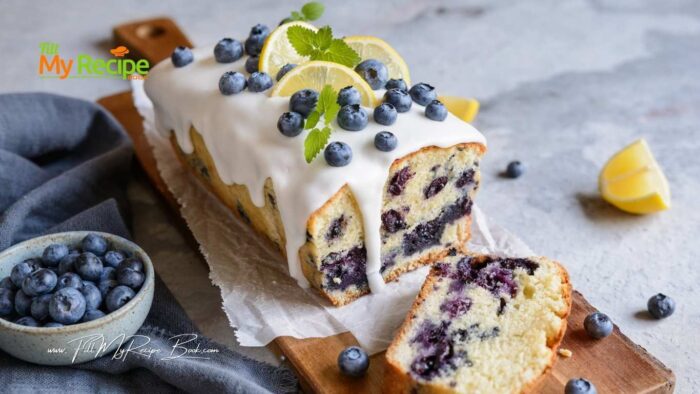 see the recipe for full instructions.
Add this loaf cake to the preheated oven and bake for 55-65 minutes. Depending on your stove.
Check with a toothpick or a clean knife if it is baked. The knife will come out clean if done.
Cool the blueberry loaf in the pan for about 10 minutes before removing and leaving on the cooling rack to cool further.
Prepare the glaze, by whisking up the melted butter, sugar and lemon juice and vanilla.
Place your cooled baked blueberry loaf that is on a cooling rack on top of a tray. Pour the glaze over the loaf. Allow it to set.