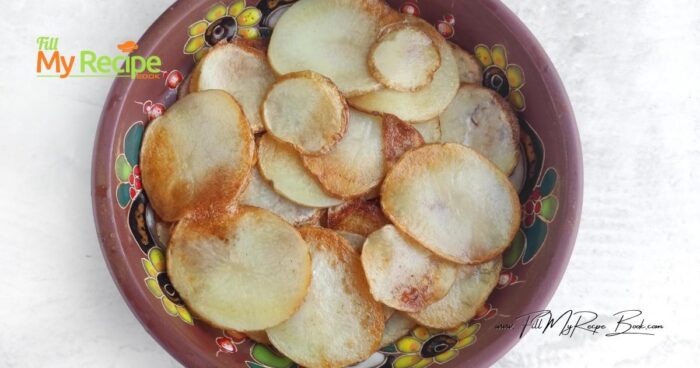 Wash the potatoes under running water. Cut into 1/8-inch-thick slices. Place the slices in a bowl and rinse with water to remove excess starch. Pat dry with a towel.
Heat the vegetable oil in a frying pan. Place the potato slices in a single layer and fry until golden brown on both sides. Transfer the cooked slices to a paper towel.
Use a ceramic baking dish. Grease it with oil and arrange the potato slices in layers. Season the potatoes with salt and pepper.