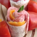 Make these festive Holiday Pinwheel Snack Skewers in just 10 minutes! Whole-wheat tortillas, salami, cheddar, and cream cheese for easy appetizers.