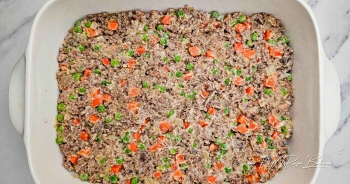 Mix the seasonings into the meat.
Add the cream of mushroom, carrots and peas. Mix well.
Pour the mixture into the casserole dish.
