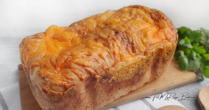 Turn the oven on and preheat to 450 deg. F. (232 deg. C).
Grease the bottom and sides of a rectangular loaf pan with butter. Place the dough in the pan, cheese side down. Cover the pan with plastic wrap and let rise for 30 minutes. Remove the wrap. Sprinkle the roll with cheese.