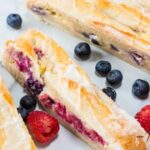 Bake a buttery Lemon Glazed Homemade Berry Danish with flaky pastry, sweet cream cheese, and fresh berries for a bakery-style treat at home.