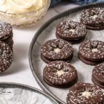 Chocolate Linzer Cookies Recipe made with a soft, buttery chocolate dough, a hint of espresso, and filled with a rich cream cheese frosting.