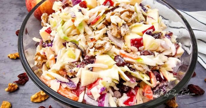 Wash and dice the apple. Add some lemon juice to prevent it browning.

In a small bowl, stir together the mayonnaise, lemon juice and sugar until creamy.

Mix the shredded cabbages, diced apples, dried cranberries and walnuts together in a large bowl.  Pour the dressing over and stir to combine.