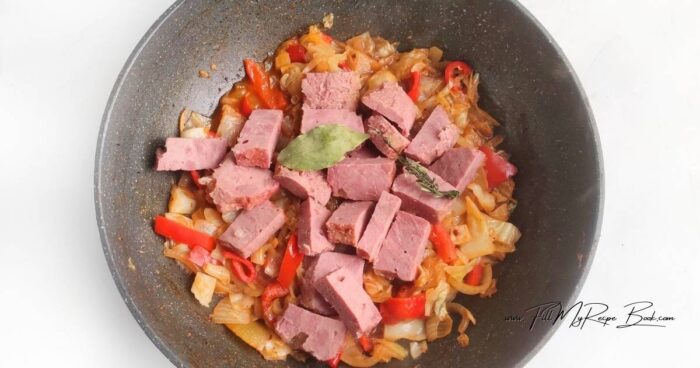 Peel the onion and bell pepper. Cut the vegetables into strips. Heat the oil in a frying pan until hot. Add the vegetables and cook for 2 minutes.
Add the spices, crushed garlic, and tomato paste and continue cooking for 2 minutes.
Trim the cabbage and cut into squares.
Add the cabbage to the pan and stir. Simmer for 3-4 minutes, until the cabbage has slightly softened. Add water and continue cooking for 10 minutes.
Add the beef to the pan and stir gently to maintain the texture. Add the bay leaf and thyme. Cook, covered, over low heat for 5 minutes.