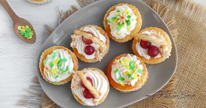 Mix the cream cheese with the condensed milk. Transfer the cream to a pastry bag. Pipe the cream into the baskets. Push the handles into the cream. Arrange the grapes and sprinkle with chocolate chips.